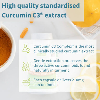 Curcumin C3 Complex supplement with turmeric powder, capsules, and lemon slices on a white background.